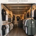 Une boutique mobile de t-shirts exposée lors d'un festival, avec divers designs créatifs.