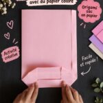 Sac en papier coloré sur une table de travail avec des fournitures de bricolage